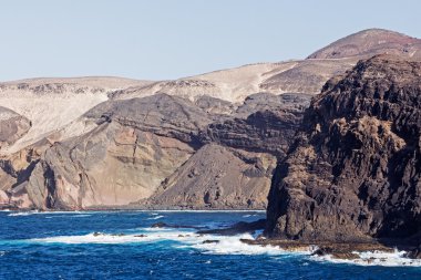 Sea surf on the rocks in area  Punta Pesebre  on Fuerteventura clipart