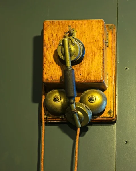 Telefone velho com um cabo na parede de metal — Fotografia de Stock