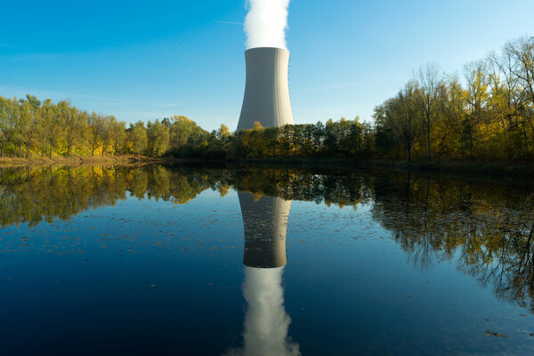 Nuclear power plant next the pond and its reflection in water