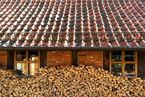 家のレンガの壁の横に薪を積み上げ — ストック写真