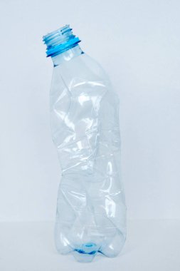 boş bir beyaz zemin üzerine izole mavi plastik şişe parçaladı