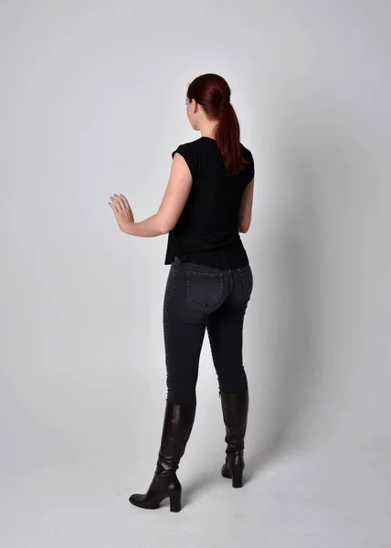 머리에 티셔츠와 바지를 여성의 카메라 스튜디오 배경에 — 스톡 사진