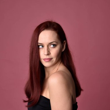 Pembe stüdyo arka planında farklı yüz ifadeleri olan kızıl saçlı kadınların yakın plan portresi..