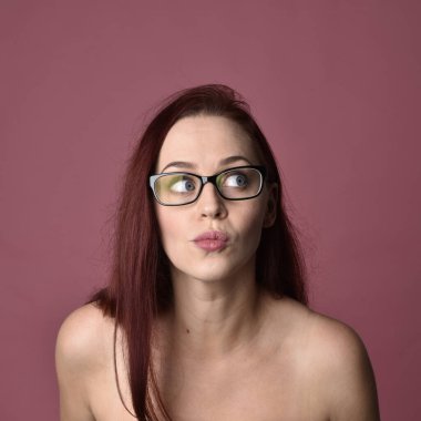 Pembe stüdyo arka planında farklı yüz ifadeleri olan kızıl saçlı kadınların yakın plan portresi..