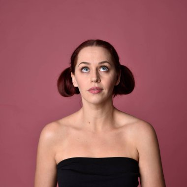 Pembe stüdyo arka planında farklı yüz ifadeleri olan kızıl saçlı kadınların yakın plan portresi..