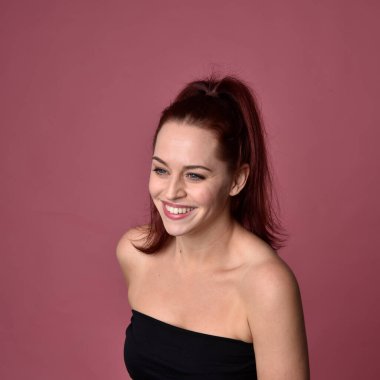 Pembe stüdyo arka planında farklı yüz ifadeleri olan kızıl saçlı kadınların yakın plan portresi..