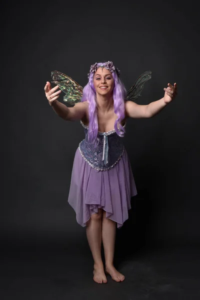 全长肖像一个紫色头发的女孩穿着幻想紧身衣与仙女翅膀和花冠 在黑暗的演播室背景下摆姿势 — 图库照片