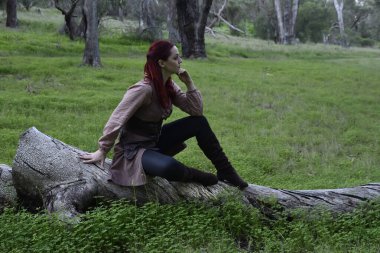 Gezgin bir maceracının fantezi ortaçağ kıyafetleri giyen kızıl saçlı kızın portresi. Orman ormanlarında doğal ışık..