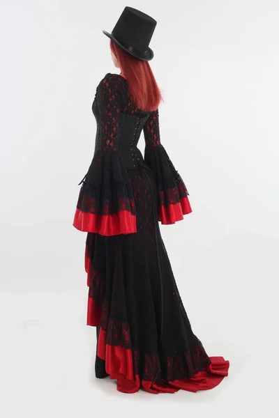 全长肖像红头发女人穿着黑色的哥特式吸血鬼长袍 在白色工作室的背景下摆姿势 — 图库照片