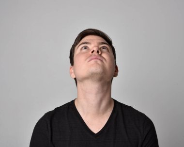 Bir esmerin kafa ve omuz portresini kapat. Çeşitli yüz ifadeleri olan genç bir adam. Açık gri stüdyo arka planında izole edilmiş..