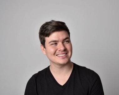 Bir esmerin kafa ve omuz portresini kapat. Çeşitli yüz ifadeleri olan genç bir adam. Açık gri stüdyo arka planında izole edilmiş..