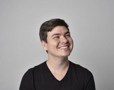 Bir esmerin kafa ve omuz portresini kapat. Çeşitli yüz ifadeleri olan genç bir adam. Açık gri stüdyo arka planında izole edilmiş..