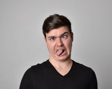 Bir esmerin kafa ve omuz portresini kapat. Çeşitli yüz ifadeleri olan genç bir adam. Açık gri stüdyo arka planında izole edilmiş..