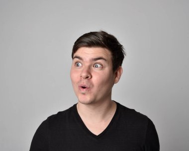 Bir esmerin kafa ve omuz portresini kapat. Çeşitli yüz ifadeleri olan genç bir adam. Açık gri stüdyo arka planında izole edilmiş..