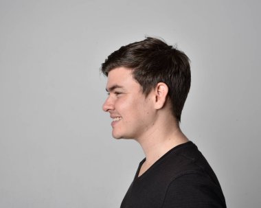 Bir esmerin kafa ve omuz portresini kapat. Çeşitli yüz ifadeleri olan genç bir adam. Açık gri stüdyo arka planında izole edilmiş..