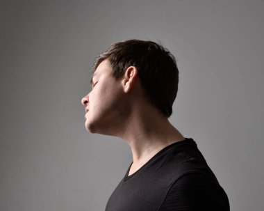 Bir esmerin kafa ve omuz portresini kapat. Çeşitli yüz ifadeleri olan genç bir adam. Açık gri stüdyo arka planında izole edilmiş..