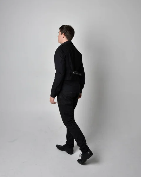 黒いシャツとゴシックのウエストコートを着たブルネットの男の完全な長さの肖像画 灰色のスタジオの背景に隔離された立ちポーズ — ストック写真