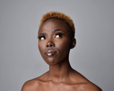 Saçları doğal olan güzel bir Afrikalı kadının kafa ve omuzlarını kapatın. çeşitli duygusal yüz ifadeleri. Açık gri stüdyo arka planında izole edilmiş..