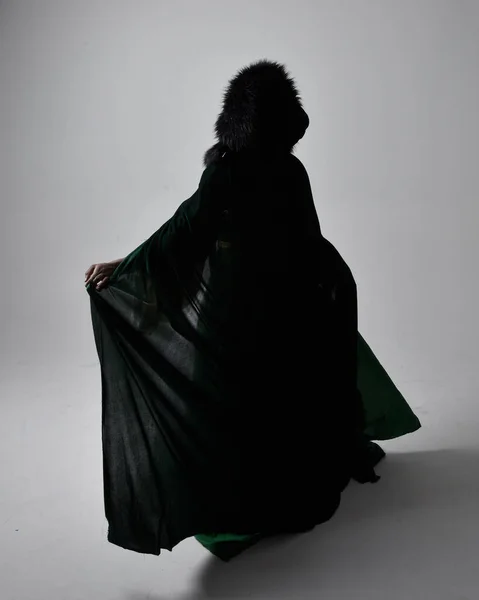 長い緑の中世のファンタジーのガウンとベルベットのマントを身に着けているかなりアフリカの女性の完全な長さの肖像画 座っているライトグレーのスタジオの背景 — ストック写真