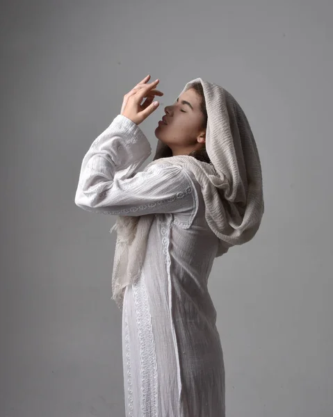 고전적 가운을 양식으로 머리덮개를 여성의 녹음실 배경에 예배를 드리고 — 스톡 사진