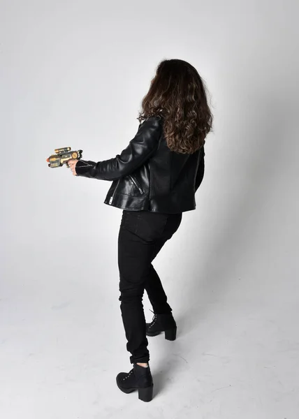 自然な茶色の髪を持つ若い女性の完全な長さの肖像画 ジャケットと黒革のScifi衣装を身に着けています ライトスタジオの背景に立ってポーズ — ストック写真