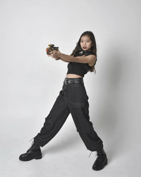 실용적 바지와 부츠를 아시아인 소녀의 스튜디오 배경에 고립되어 — 스톡 사진