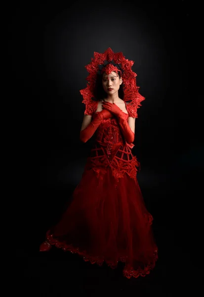 赤のコルセット 長いオペラ手袋 華やかなゴシック女王の王冠を身に着けている美しい若いアジアの女性の劇的な肖像画 暗いスタジオの背景に隔離された優雅なポーズ — ストック写真