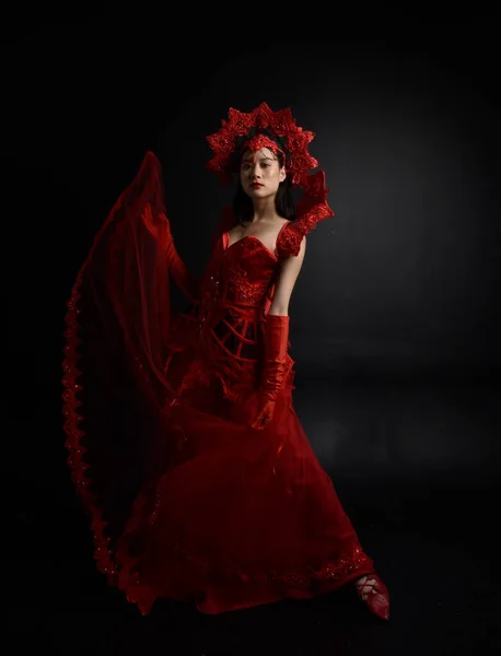 穿着红色紧身衣 戴着长长的歌剧手套 头戴华丽的哥特式女王王冠的美丽年轻亚洲女人的戏剧性画像 优雅的姿势在黑暗的工作室背景下被隔离 — 图库照片