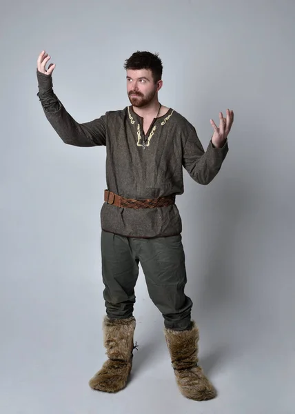 年轻英俊男子穿着中世纪凯尔特冒险家服装的全长肖像 独立于工作室背景的站立姿势 — 图库照片