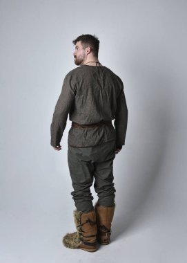 Orta Çağ Kelt maceraperest kostümü giymiş yakışıklı bir adamın tam boy portresi. Stüdyo arka planında izole edilmiş poz.