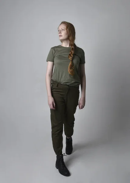 카키색 셔츠와 실용적 바지와 부츠를 여성의 초상화 스튜디오 배경에 고립된 — 스톡 사진