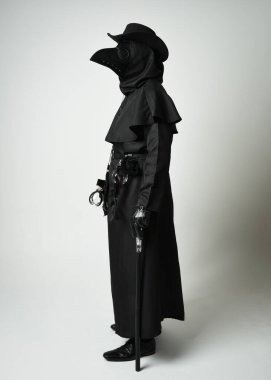 Veba Doktoru Tam Boylu Yürüyen Siluet Gotik Cadılar Bayramı Karakteri Gaga Maskeli Siyah Pelerin Beyaz Stüdyo Arkaplan, Dramatik Karanlık Kostüm ve Fantezi Korku figürü