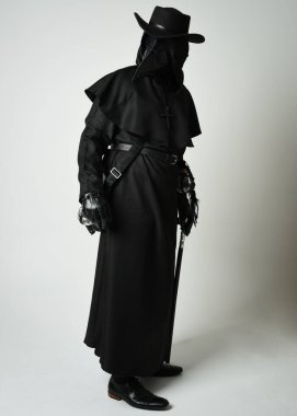 Veba Doktoru Tam Boylu Yürüyen Siluet Gotik Cadılar Bayramı Karakteri Gaga Maskeli Siyah Pelerin Beyaz Stüdyo Arkaplan, Dramatik Karanlık Kostüm ve Fantezi Korku figürü