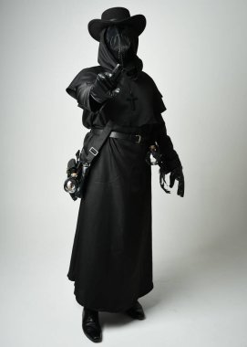 Veba Doktoru Tam Boylu Yürüyen Siluet Gotik Cadılar Bayramı Karakteri Gaga Maskeli Siyah Pelerin Beyaz Stüdyo Arkaplan, Dramatik Karanlık Kostüm ve Fantezi Korku figürü