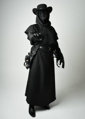 Veba Doktoru Tam Boylu Yürüyen Siluet Gotik Cadılar Bayramı Karakteri Gaga Maskeli Siyah Pelerin Beyaz Stüdyo Arkaplan, Dramatik Karanlık Kostüm ve Fantezi Korku figürü