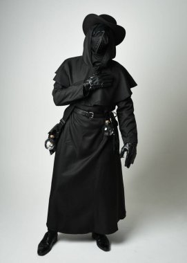 Veba Doktoru Tam Boylu Yürüyen Siluet Gotik Cadılar Bayramı Karakteri Gaga Maskeli Siyah Pelerin Beyaz Stüdyo Arkaplan, Dramatik Karanlık Kostüm ve Fantezi Korku figürü