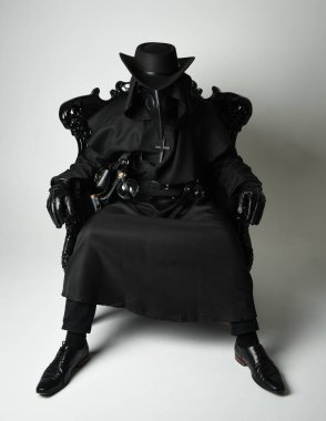 Fenerli Gotik Veba Doktoru, Kara Pelerinli Cadılar Bayramı Karakteri, Kuş Maskeli, kadife taht koltuğunda oturan. Gizemli Fantezi Korku figürünün Stüdyo Portresi