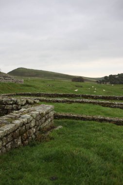 Antik Roma İmparatorluğu anıtı Hadrians Duvarı 'nın engebeli İskoç dağlık kırsalındaki sinematik manzarası rüzgarlı bir bozkıra çarpan tarihi bir dönüm noktası.