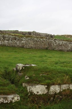 Antik Roma İmparatorluğu anıtı Hadrians Duvarı 'nın engebeli İskoç dağlık kırsalındaki sinematik manzarası rüzgarlı bir bozkıra çarpan tarihi bir dönüm noktası.