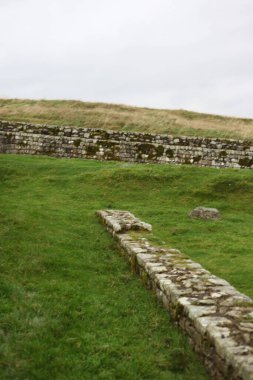 Antik Roma İmparatorluğu anıtı Hadrians Duvarı 'nın engebeli İskoç dağlık kırsalındaki sinematik manzarası rüzgarlı bir bozkıra çarpan tarihi bir dönüm noktası.