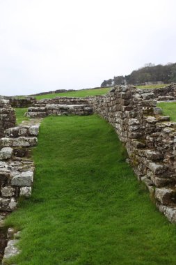 Antik Roma İmparatorluğu anıtı Hadrians Duvarı 'nın engebeli İskoç dağlık kırsalındaki sinematik manzarası rüzgarlı bir bozkıra çarpan tarihi bir dönüm noktası.