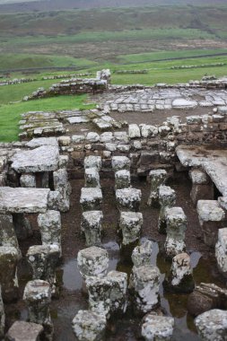 Antik Roma İmparatorluğu anıtı Hadrians Duvarı 'nın engebeli İskoç dağlık kırsalındaki sinematik manzarası rüzgarlı bir bozkıra çarpan tarihi bir dönüm noktası.
