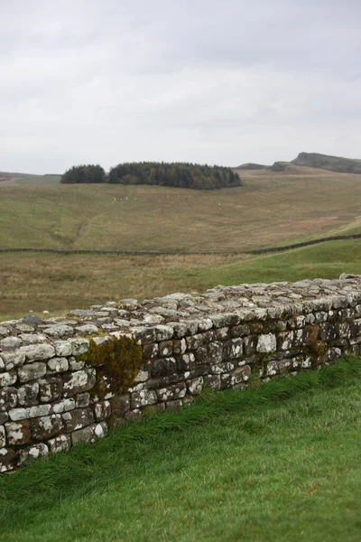Antik Roma İmparatorluğu anıtı Hadrians Duvarı 'nın engebeli İskoç dağlık kırsalındaki sinematik manzarası rüzgarlı bir bozkıra çarpan tarihi bir dönüm noktası.