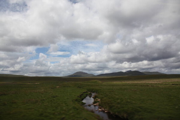 Highland valleys of Glen Coe in Scotland, showcasing rugged mountains, deep glens, and expansive views across a dramatic ancient European  landscape