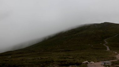 Ben Nevis 'in İskoçya' daki zirvesinde, kayalık zirvede süzülen bulutlar dramatik dağ atmosferini ve değişen dağ havasını yakalıyor..