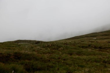 Ben Nevis 'in İskoçya' daki zirvesinde, kayalık zirvede süzülen bulutlar dramatik dağ atmosferini ve değişen dağ havasını yakalıyor..