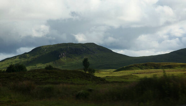 Highland valleys of Glen Coe in Scotland, showcasing rugged mountains, deep glens, and expansive views across a dramatic ancient European  landscape