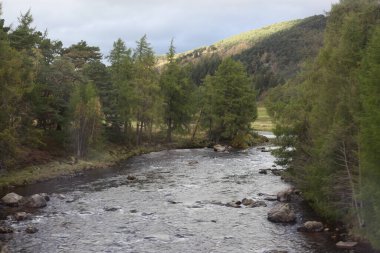 İskoçya 'da sonbaharda dağ zirveleri ve engebeli yamaçlarla çevrili bir dağ gölü. İskoçya' nın dramatik dağlık arazisini yansıtan bir su.