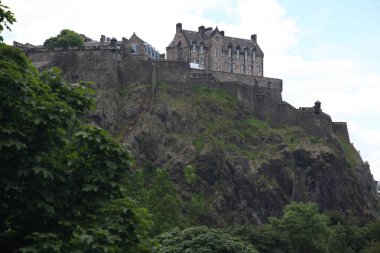 Edinburgh Şatosu bir tepenin üstünde yükseliyor, İskoç siluetine hükmeden tarihi bir ortaçağ taş kalesi, antik mimari, siperler, surlar ve İskoçya 'nın kalıcı mirasını sergiliyor.