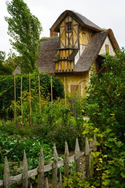 Trianon 'daki Hameau de la Reine, Marie Antoinettes pastoral malikanesi büyüleyici kır evleri, manzaralı çiçek bahçeleri, Fransız kırsalının tarihi zarafetini ve güzelliğini gözler önüne seriyor.